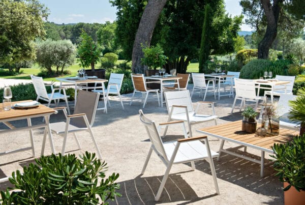 Terras horeca met witte stoelen en teak tafels